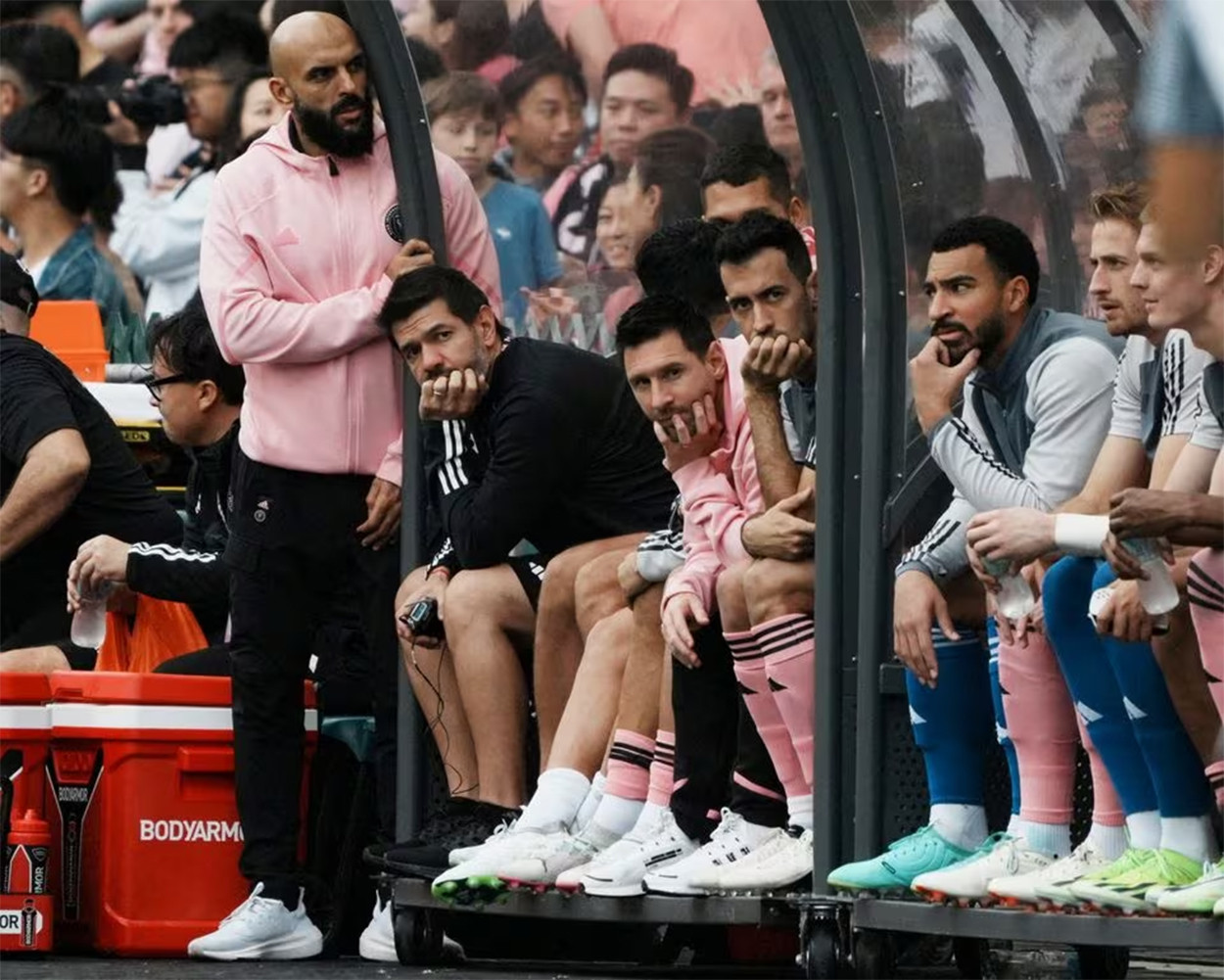 inter miami s lionel messi sergio busquets and teammates sit on the substitute bench during the match as lionel messi security guard yassine cheuko looks on photo reuters