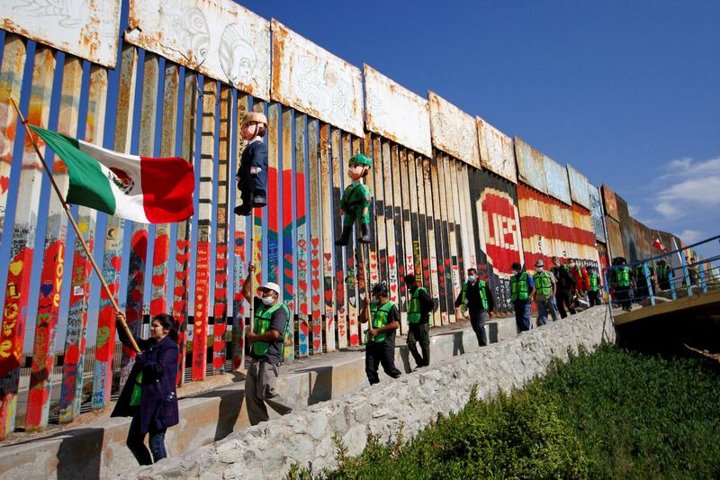 file photo migrants and members of civil society hold pinatas in the image of u s president donald trump and a border patrol officer during a protest against stalled asylum claims and the building of the wall at the border fence between mexico and the u s in tijuana mexico october 31 2020 reuters jorge duenes