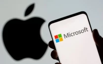 microsoft logo is seen on the smartphone in front of displayed apple logo in this illustration taken july 26 2021 photo reuters file