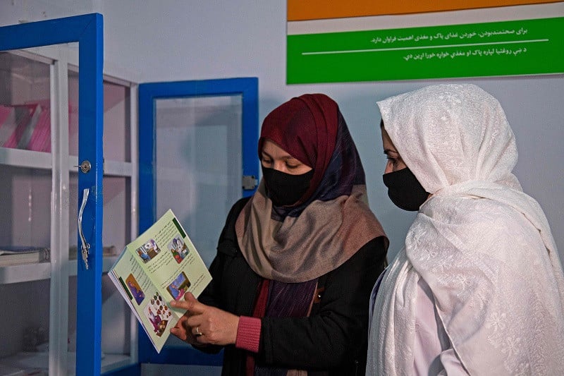 Momina Kohistani (L), head midwife at Norwegian Afghanistan Committee (NAC)-run Comprehensive-Continuum of Care Centre, a maternity hospital, shows a catalogue to fellow midwife Zainab Dawlatzai, in the facility at Gardez, the capital of Afghanistan's Paktia province, December 7, 2023. PHOTO: AFP