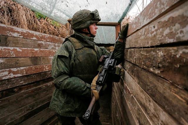 a militant of the self proclaimed donetsk people s republic dnr watches from a frontline position on the line of separation from the ukrainian armed forces outside of the rebel controlled city of donetsk ukraine november 19 2021 photo reuters