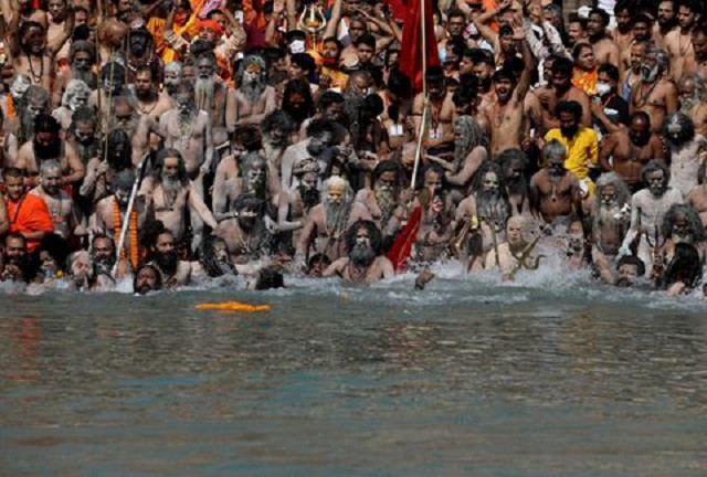 SENSITIVE MATERIAL. THIS IMAGE MAY OFFEND OR DISTURB Naga Sadhus, or Hindu holy men take a holy dip in the Ganges River during Shahi Snan at 