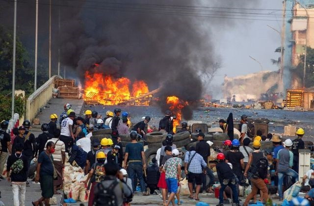 anti coup protesters stand at a barricade as they clash with security forces on bayint naung bridge in mayangone yangon myanmar march 16 2021 photo reuters