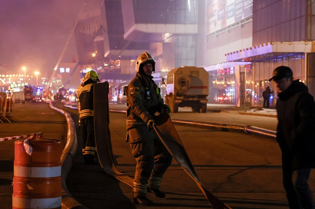 Firefighters work near the burning Crocus City Hall concert venue following the terror attack, outside Moscow, Russia. PHOTO: Reuters