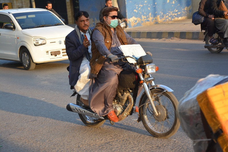 A majority of motorcyclist in Karachi drive around their motorcycles without rear view mirrors. PHOTO: EXPRESS
