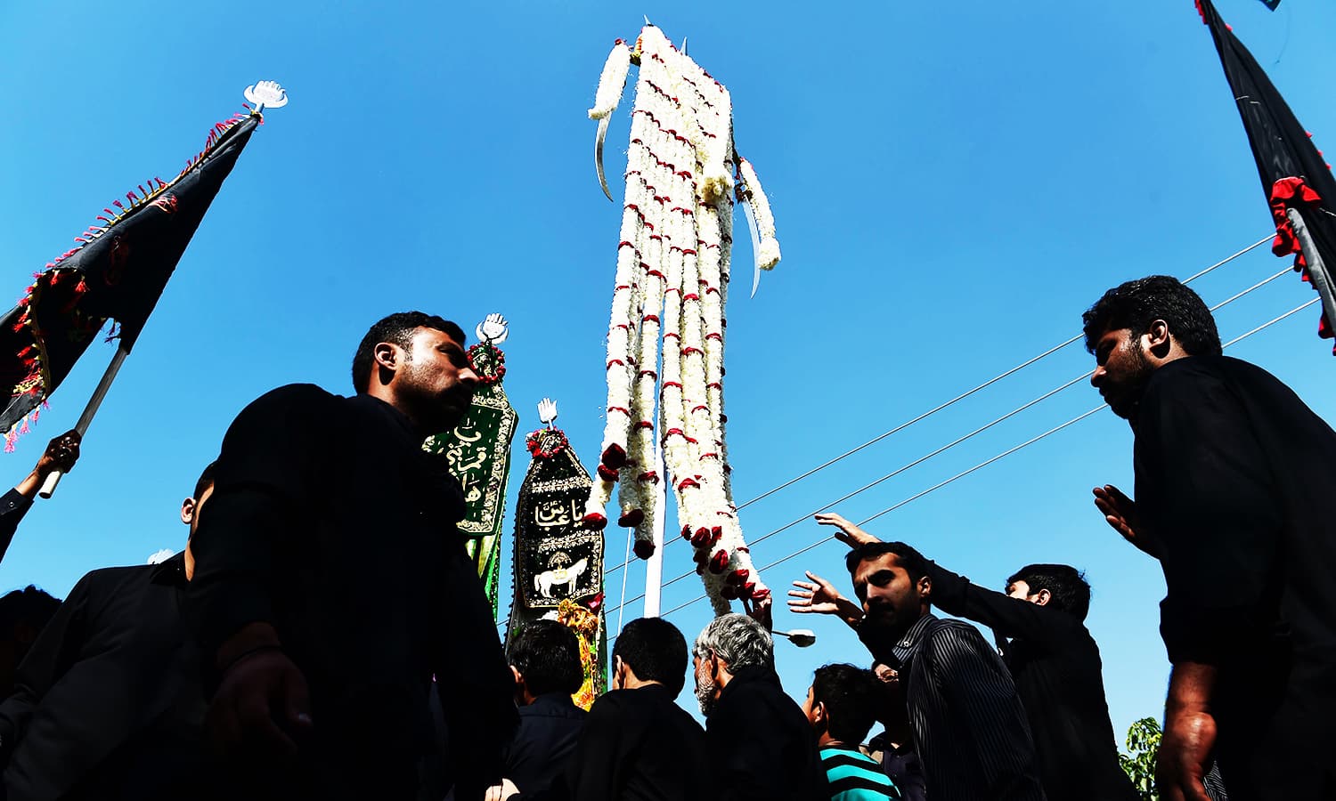 Mourners carry flags during a religious procession in Islamabad. PHOTO: AFP
