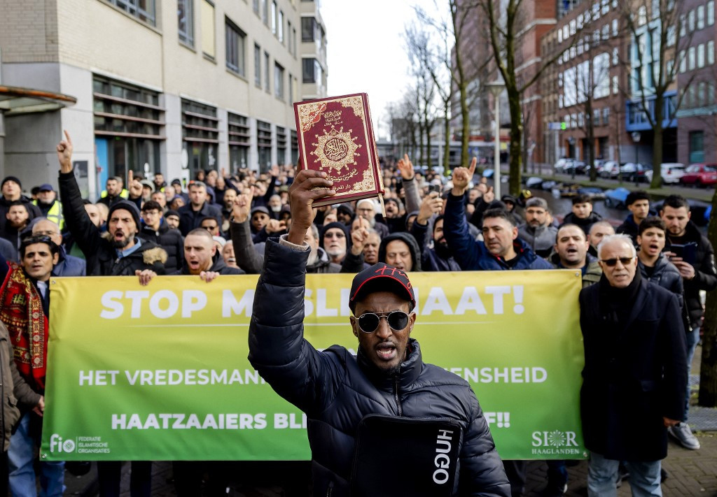 a man holding up the muslim holy book the quran leads a rally against anti muslim sentiment following a one man protest outside parliament last month where a supporter of the dutch chapter of the german anti islam group pegida tore pages out of the holy quran in the hague netherlands on february 5 2023 photo afp