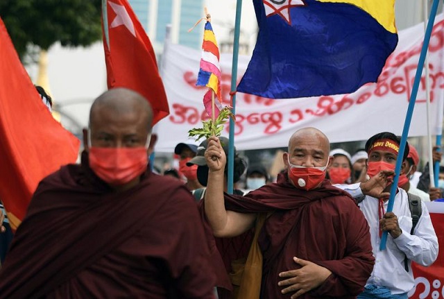 a buddhist monk holds a flag during a protest against the military coup in yangon myanmar february 22 2021 photo reuters