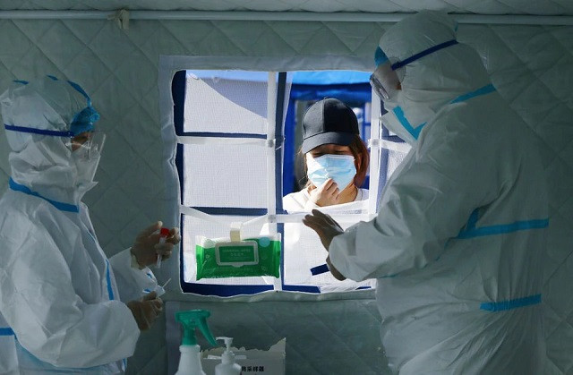 a medical worker in protective suit checks the information of a resident during a mass nucleic acid testing following a new case of the coronavirus disease covid 19 in haidong s pingan district qinghai province china october 23 2021 photo reuters