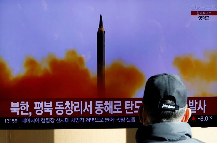 a woman walks past a tv broadcasting a news report on north korea firing a ballistic missile off its east coast in seoul south korea december 18 2022 reuters heo ran