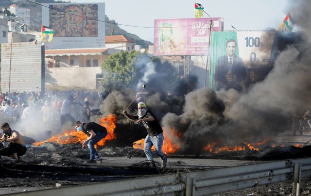 a palestinian uses a slingshot during an anti israel protest over a cross border violence between palestinian in gaza and the israeli military near hawara checkpoint near nablus in the israeli occupied west bank may 18 2021 photo reuters a palestinian uses a slingshot during an anti israel protest over a cross border violence between palestinian in gaza and the israeli military near hawara checkpoint near nablus in the israeli occupied west bank may 18 2021 photo reuters