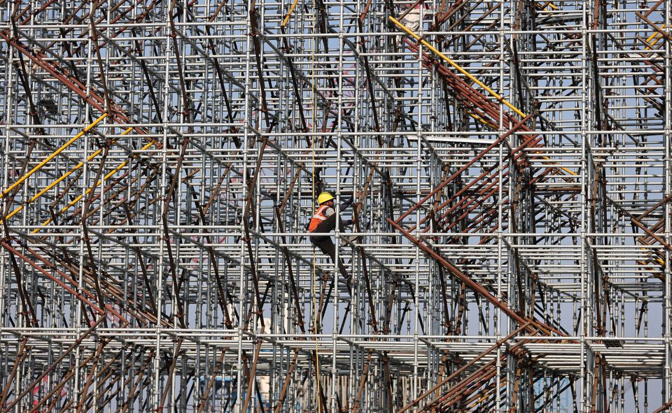 a worker climbs a scaffolding at a construction site in mumbai india january 19 2022 photo reuters
