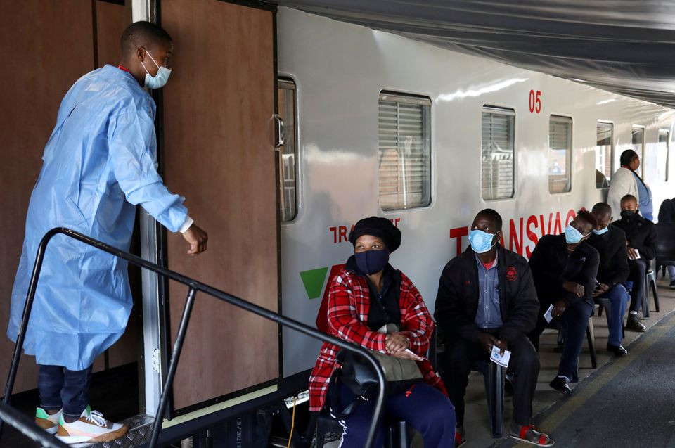 a health worker talks to people as they wait to register next to the transvaco coronavirus disease covid 19 vaccine train after south africa s rail company transnet turned the train into a covid 19 vaccination center on rails to help the government speed up its vaccine rollout in the country s remote communities at the springs train station on the east rand south africa august 30 2021 photo reuters