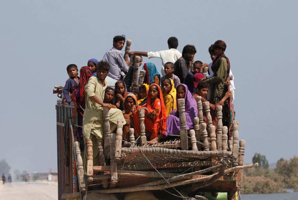 Flood victims travel with their belongings in search for a higher ground, following rains and floods during the monsoon season in Gari Yasin, Shikarpur, Pakistan August 31, 2022. REUTERS