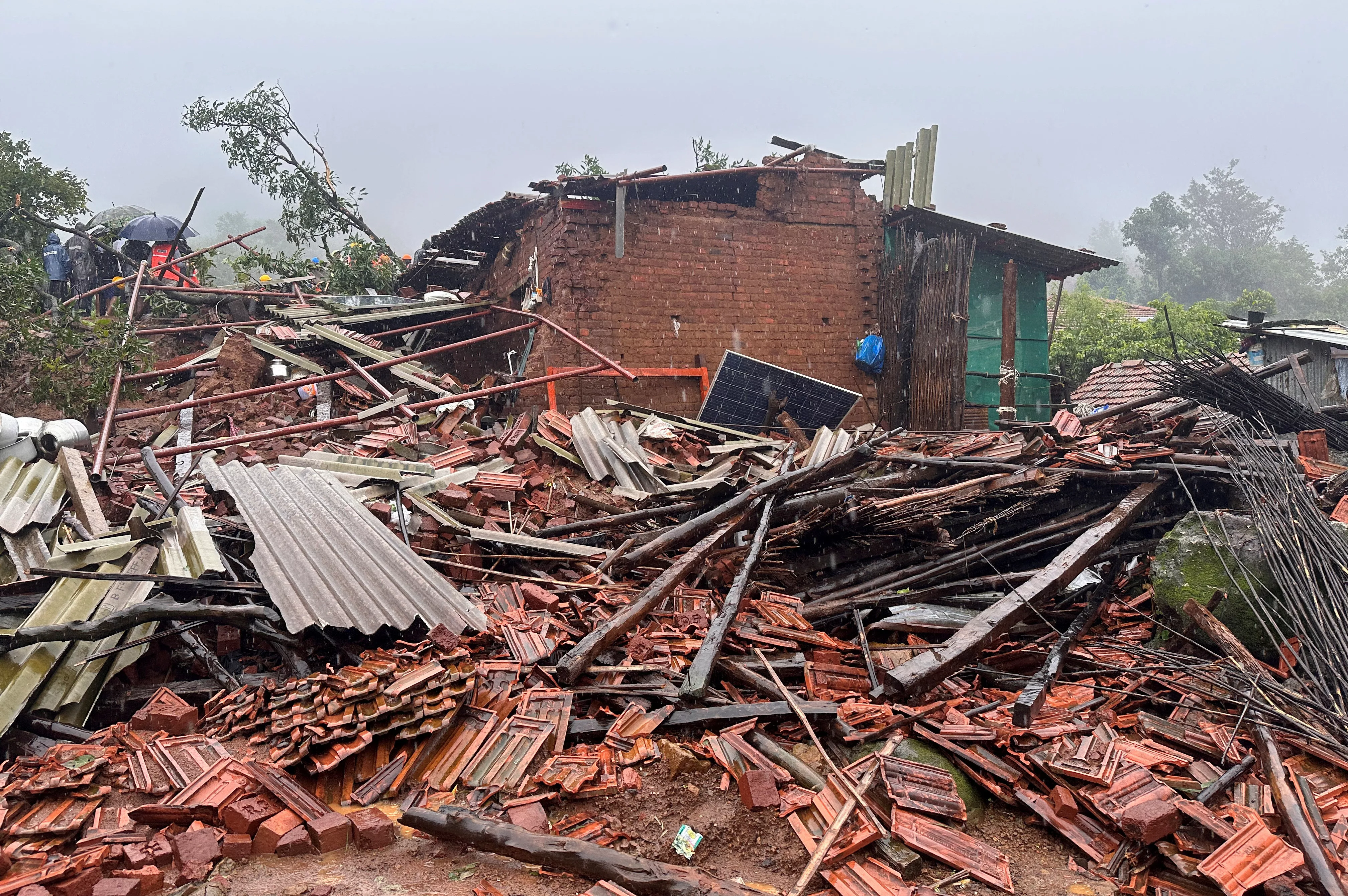 rescuers stand next to debris of a residential house that was damaged by a landslide in raigad district in the western state of maharashtra india july 20 2023 photo reuters