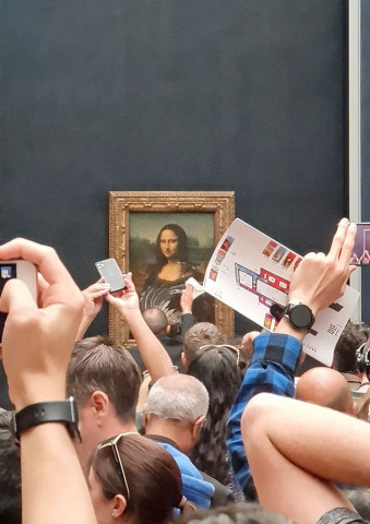 a man tries to wipe off the cake smeared on the protective glass of the painting mona lisa at the lourve museum in paris france may 29 2022 in this screen grab obtained from social media video reuters a man tries to wipe off the cake smeared on the protective glass of the painting mona lisa at the lourve museum in paris france may 29 2022 in this screen grab obtained from social media video reuters