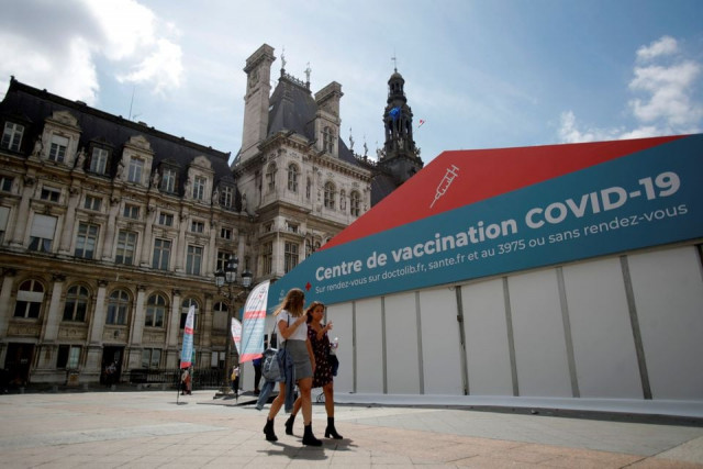 women walk past a coronavirus disease covid 19 vaccination center installated in front of paris town hall france july 7 2021 photo reuters women walk past a coronavirus disease covid 19 vaccination center installated in front of paris town hall france july 7 2021 photo reuters