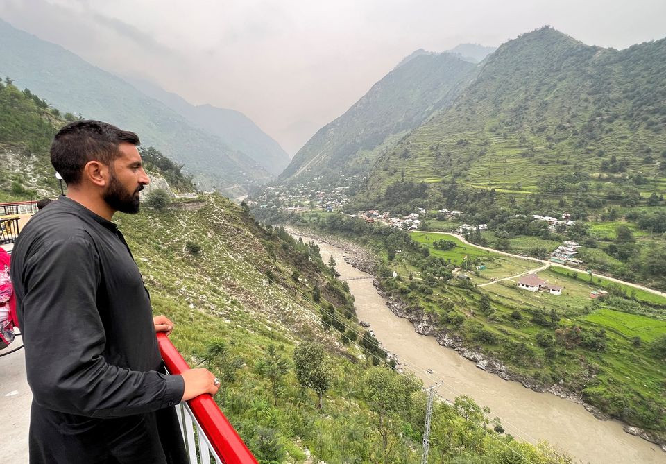 Umar Mughal, 26, stands at the vantage point offering a view of the Indian side, in Chilehana, Pakistan-India crossing point in Kashmir, Pakistan August 11, 2022. REUTERS
