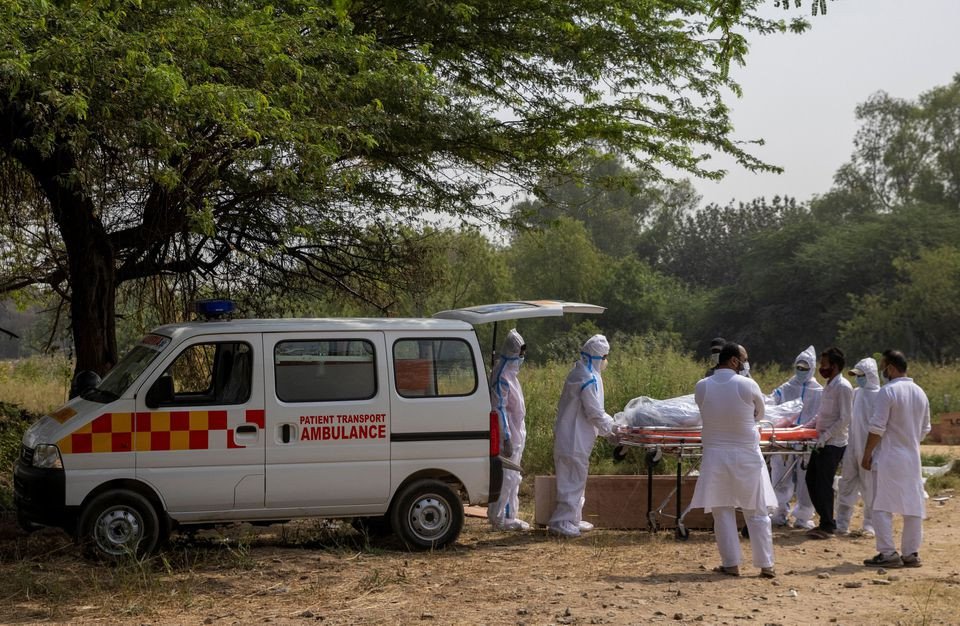 health workers carry the body of a man who died from the coronavirus disease covid 19 from an ambulance for burial at a graveyard in new delhi india april 16 2021 reuters