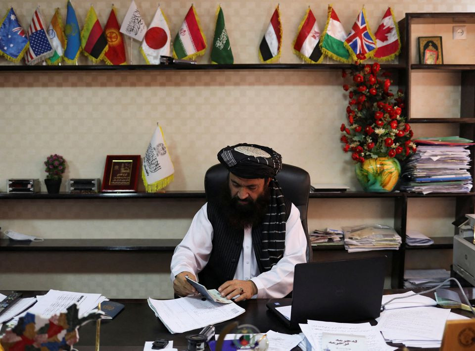 alam gul haqqani head of afghanistan passport office checks documents at his office in kabul afghanistan december 12 2021 picture taken december 12 2021 reuters