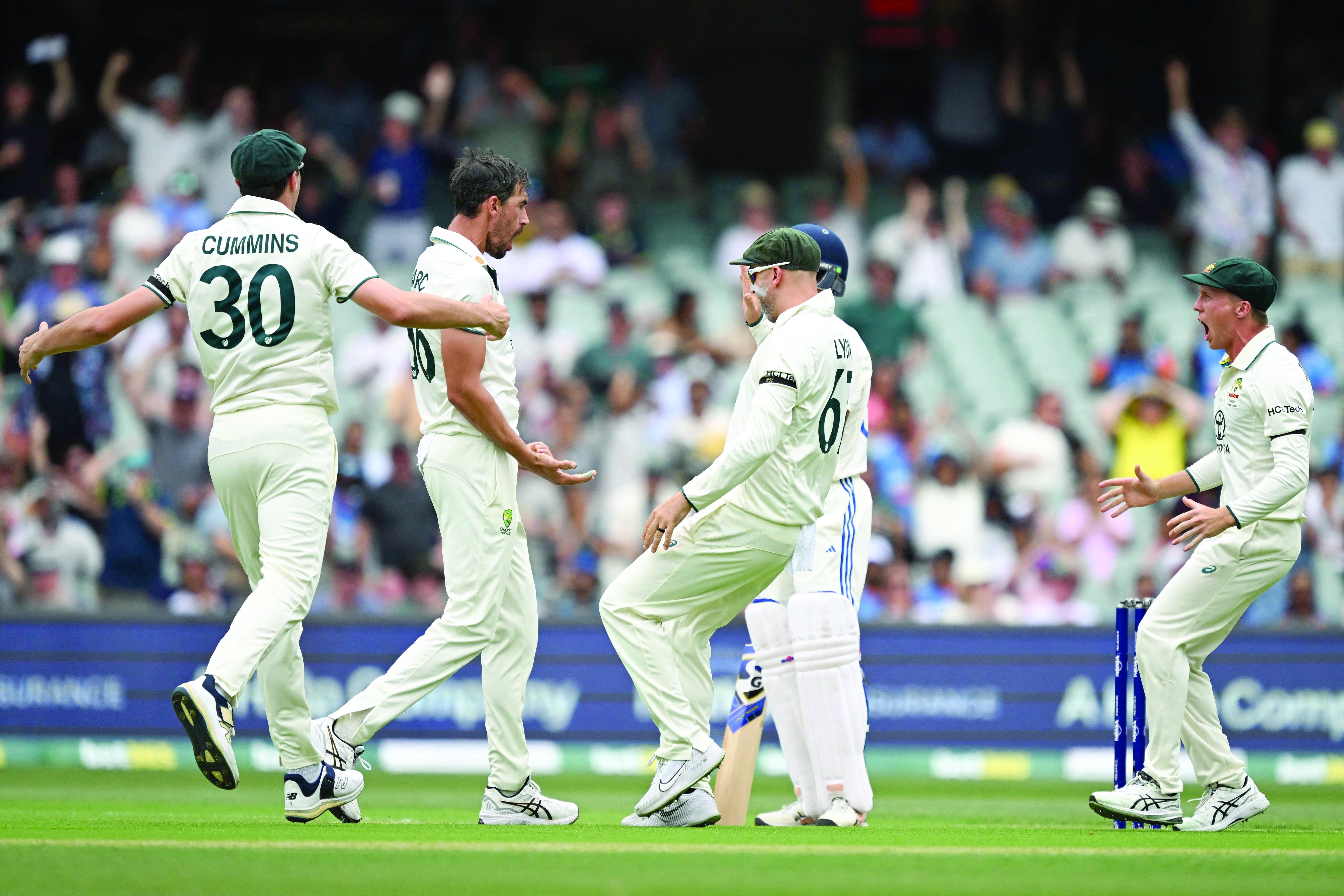 australia s mitchell starc celebrates the first ball dismissal of india s yashasvi jaiswal with teammates at the adelaide oval photo afp