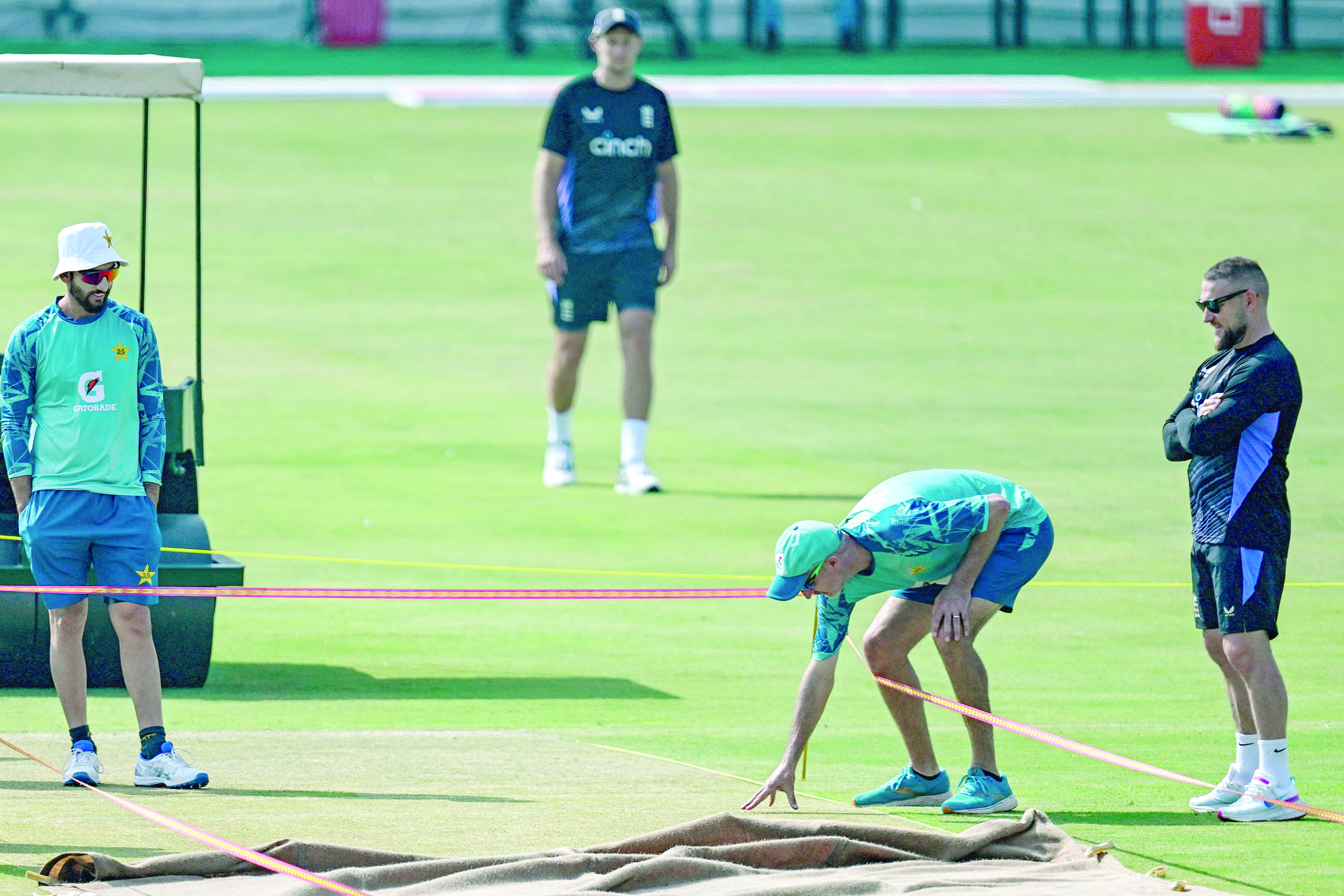 england s head coach brendon mccullum r and his pakistani counterpart jason gillespie 2r inspect the multan stadium pitch on the eve of first test on sunday photo afp