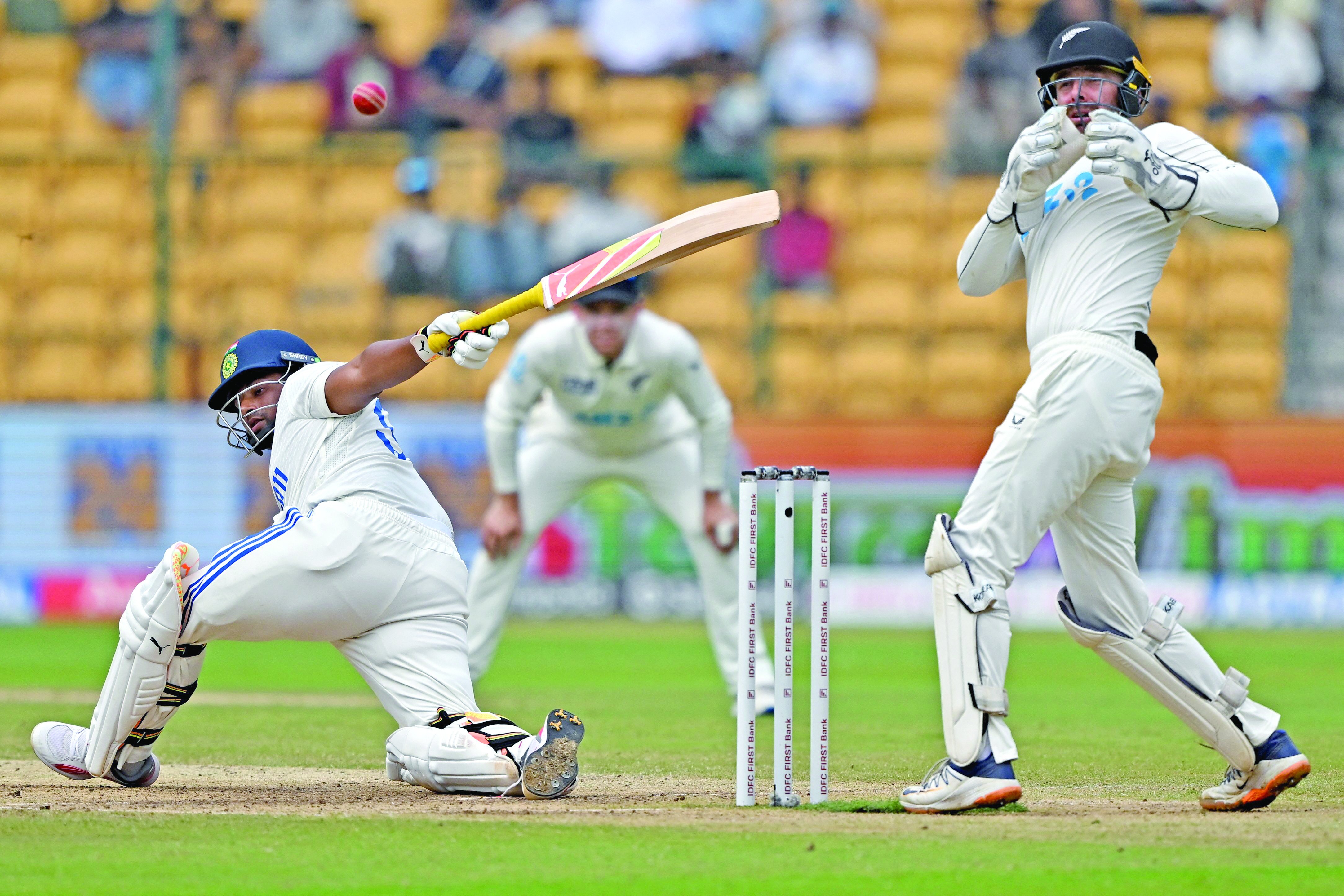 india s sarfaraz khan l plays a shot as new zealand keeper tom blundell takes evasive action on the third day of the first test in bengaluru photo afp