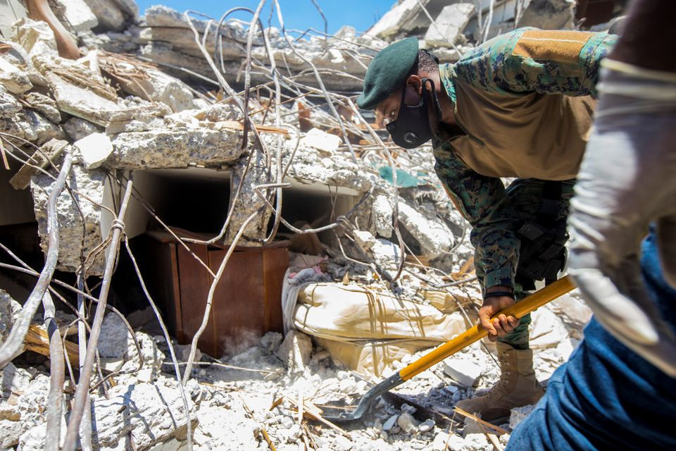 a soldier cleans debris from a house after a 7 2 magnitude earthquake in les cayes haiti august 15 2021 photo reuters