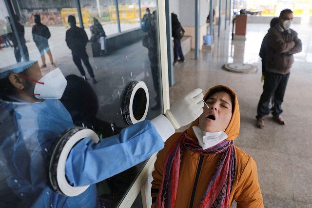 a healthcare worker collects a test swab sample from a woman amidst the spread of the coronavirus disease covid 19 at a testing centre inside a hospital in new delhi india january 14 2022 photo reuters