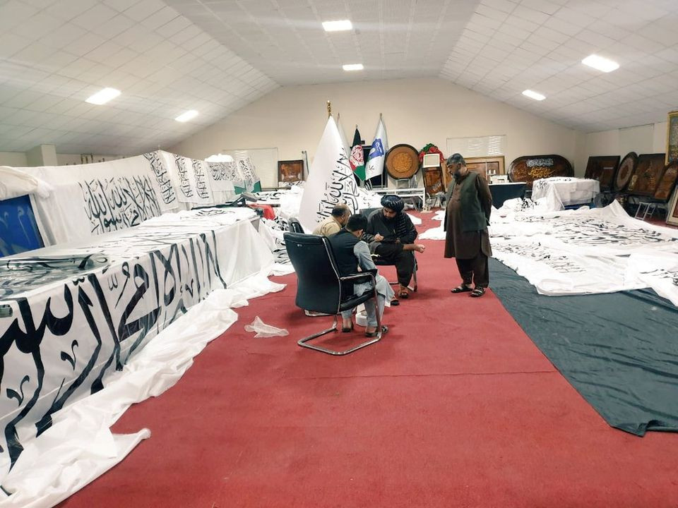 Unidentified people are surrounded by Taliban flags at an unidentified location, in this handout photo uploaded to social media on September 1, 2021. Social media handout/via REUTERS