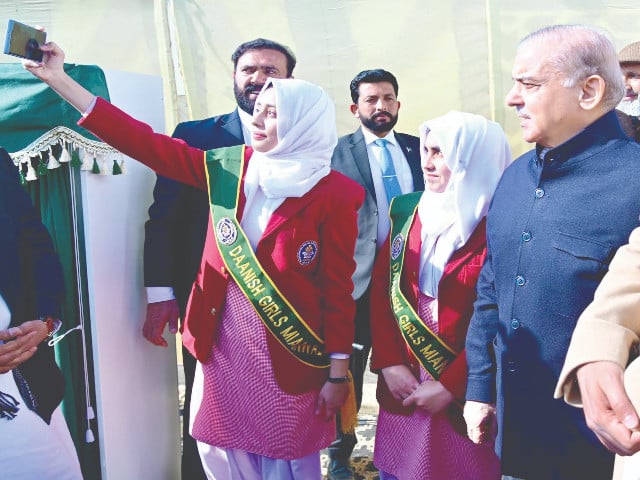 a girl takes a selfie with prime minister shehbaz sharif during his visit to the daanish school in bhimber photo ppi