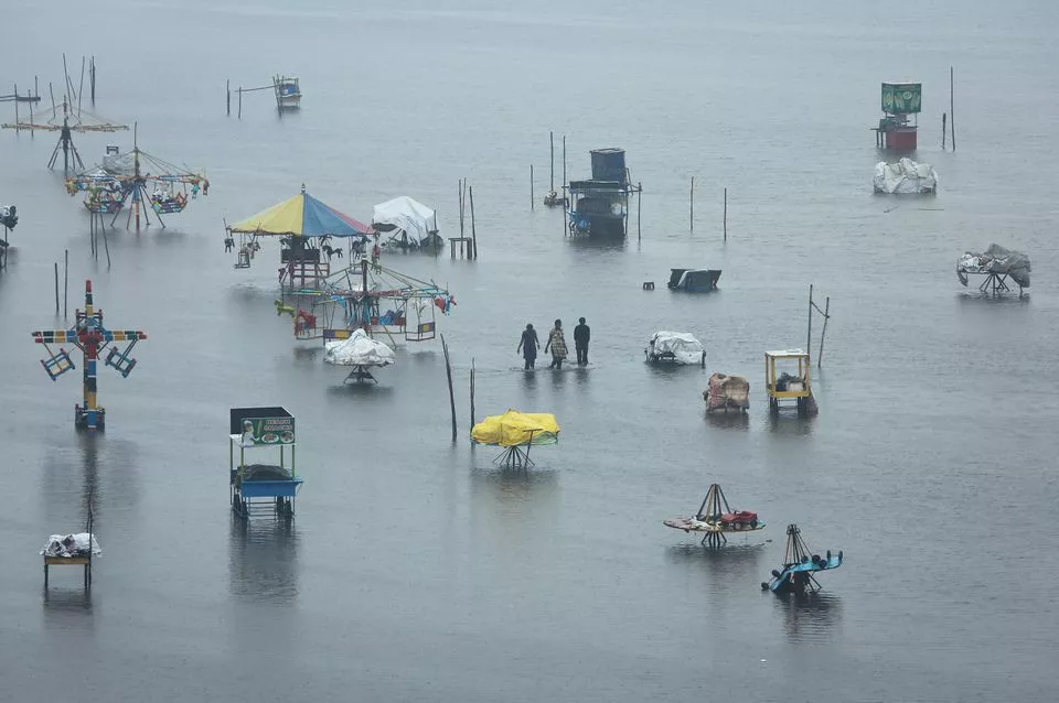 people wade through a flooded beach after heavy rainfall in chennai india november 8 2021 reuters people wade through a flooded beach after heavy rainfall in chennai india november 8 2021 reuters