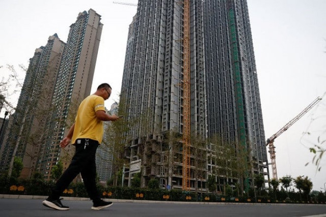 a man walks in front of unfinished residential buildings at the evergrande oasis a housing complex developed by evergrande group in luoyang china september 15 2021 photo reuters a man walks in front of unfinished residential buildings at the evergrande oasis a housing complex developed by evergrande group in luoyang china september 15 2021 photo reuters