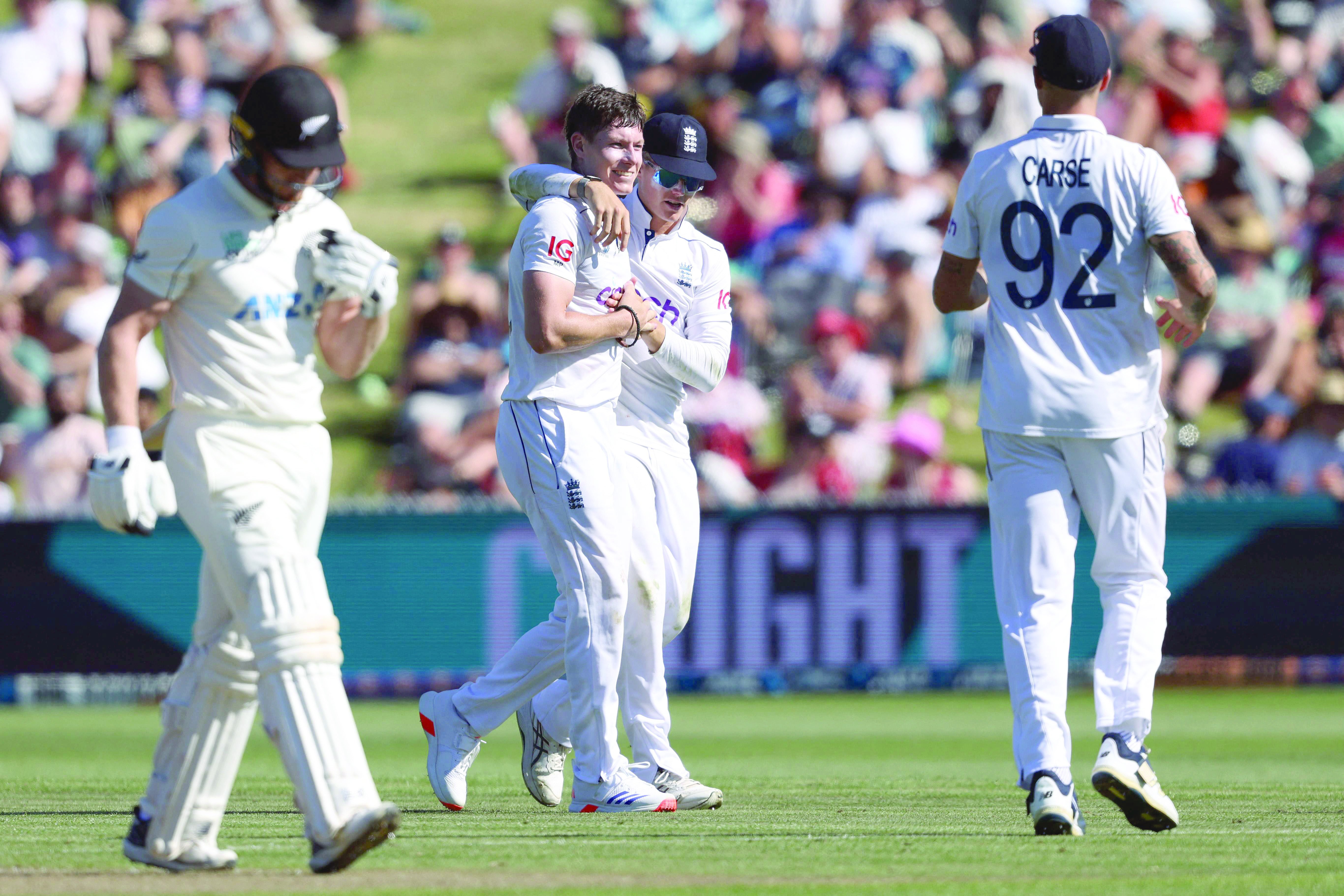 england s matthew potts and jacob bethell celebrate the wicket of new zealand s glenn phillips l on day one of the third cricket test match at seddon park in hamilton photo afp