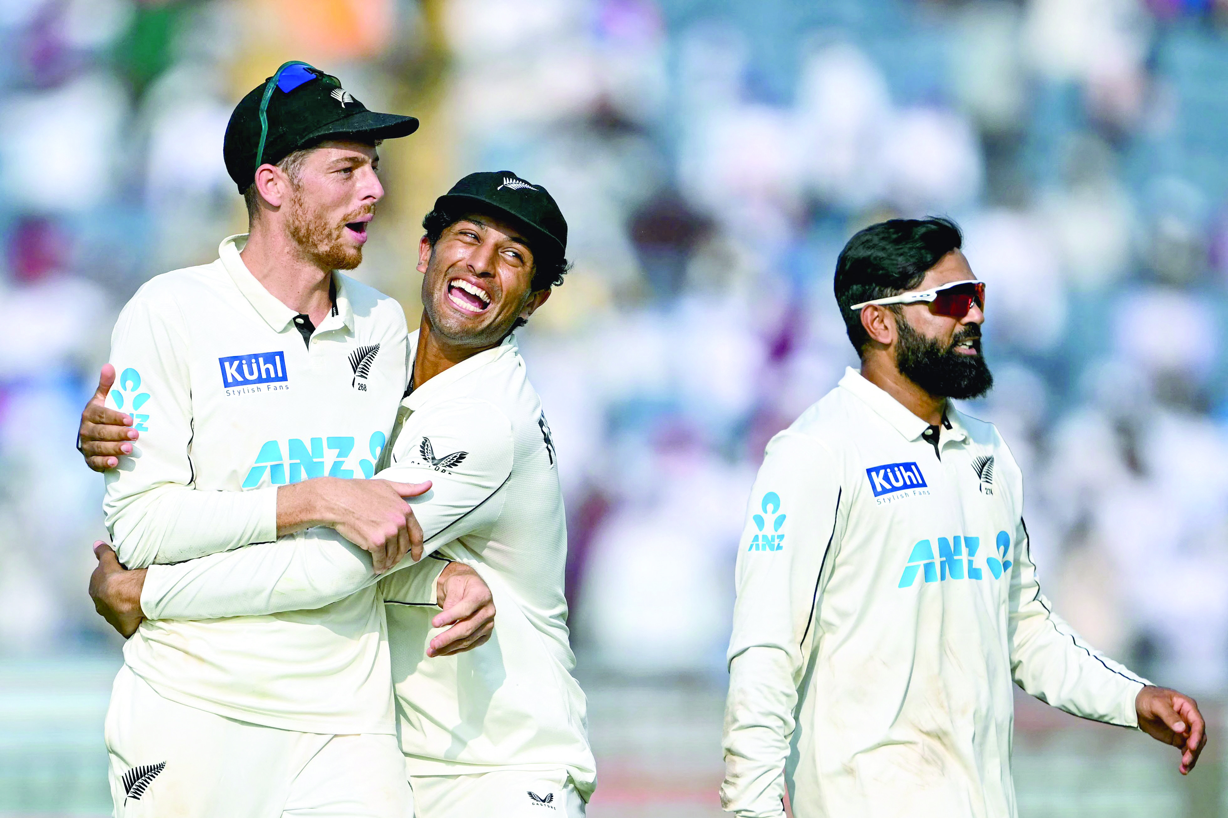 new zealand s mitchell santner l is embraced by teammate rachin ravindra c as ajaz patel r looks on as they celebrate after their win against india at the end of the third day of their second test cricket match photo afp