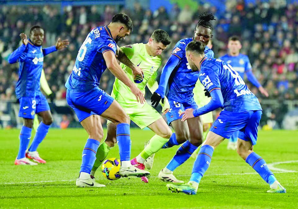 getafe s christantus uche and getafe s omar alderete in action with fc barcelona s robert lewandowski during laliga match with getafe at estadio coliseum on january 18 photo reuters