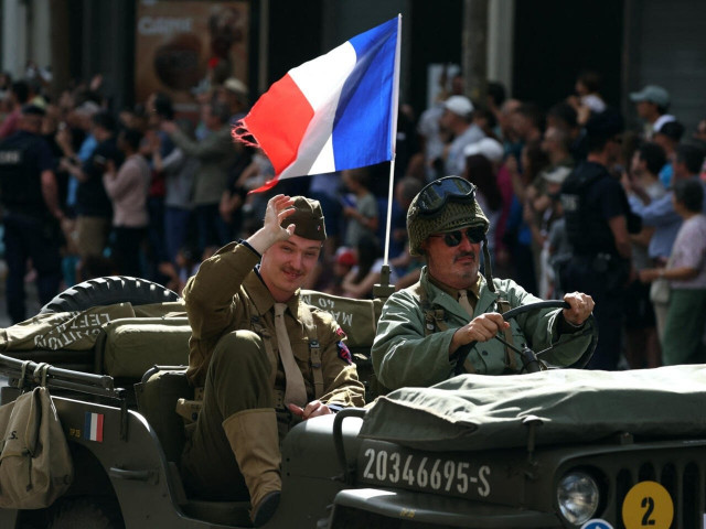 reenactors dressed in wartime uniforms parade on a military vehicle to mark the 80th anniversary of the liberation of paris on august 25 2024 photo afp reenactors dressed in wartime uniforms parade on a military vehicle to mark the 80th anniversary of the liberation of paris on august 25 2024 photo afp