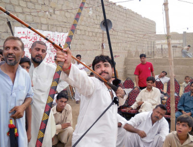 vulture feathers and rubber bows quiver as burly men take aim in ancient warrior sport