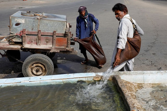 mohammad ramzan a 60 year old traditional goatskin water carrier also known as a mashki fills a water trough for pigeons along a road on a hot and humid day during the fasting month of ramazan as the outbreak of the coronavirus disease covid 19 continues in karachi pakistan april 23 2021 photo reuters