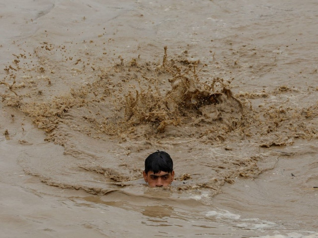 a man swims in flood waters while heading for a higher ground following rains and floods during the monsoon season in charsadda pakistan photo reuters fayaz aziz