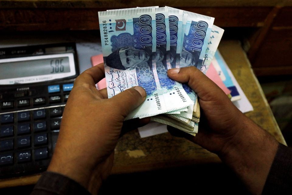 a trader counts pakistani rupee notes at a currency exchange booth in peshawar photo reuters file