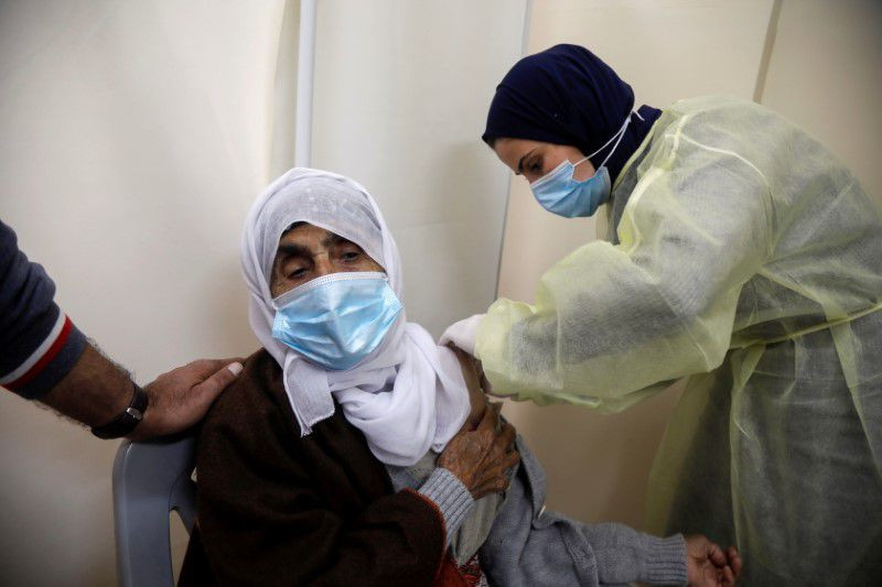 a palestinian health worker gives a woman a dose of astrazeneca vaccine against the coronavirus disease covid 19 during a vaccination drive in tubas in the israeli occupied west bank march 25 2021 photo reuters
