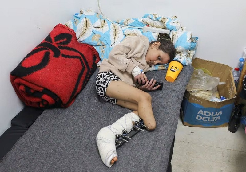 Palestinian girl Eman Al-Kholi, whose limb was amputated after being wounded in an Israeli strike that killed her parents, lies on a bed as she receives treatment at the European Hospital, in Rafah in the southern Gaza Strip, December 28, 2023. PHOTO: REUTERS