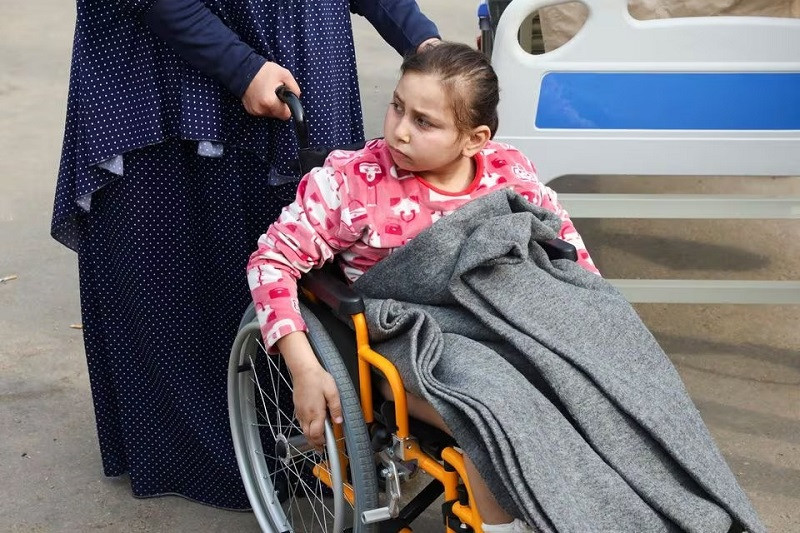 Palestinian girl Noor Marouf, whose limb was amputated after being wounded in an Israeli strike, sits in a wheelchair as she is helped by her aunt at the European Hospital, in Rafah in the southern Gaza Strip, December 28, 2023. PHOTO: REUTERS
