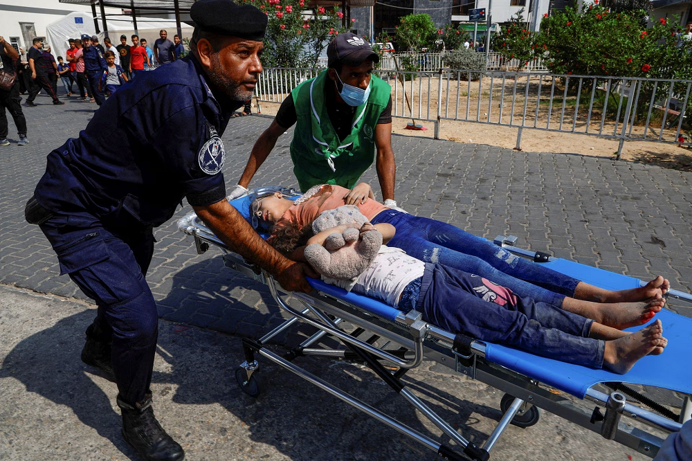 Palestinian children injured in Israeli strikes are brought to a hospital, in Gaza City, October 11. PHOTO: REUTERS