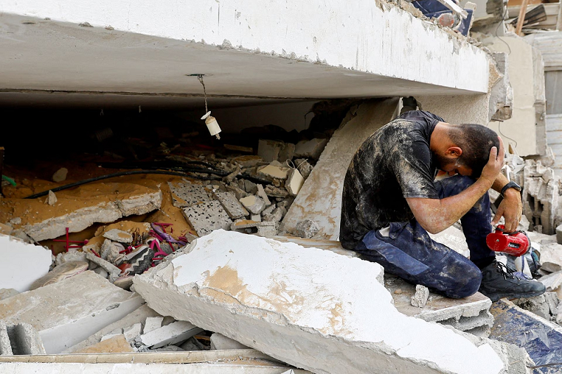 a rescuer reacts as he works with others to remove palestinian casualties from under the rubble of a house destroyed in israeli strikes in rafah in the southern gaza strip october 9 photo reuters