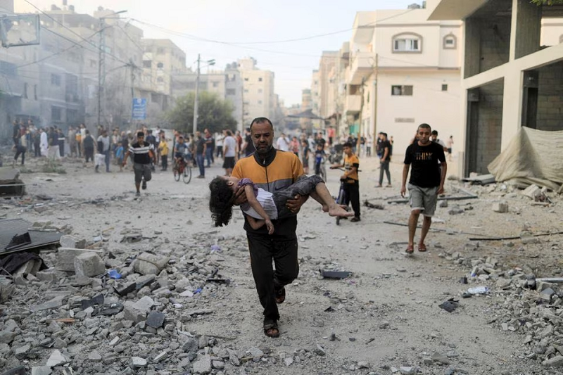 a palestinian man carries a wounded girl at the site of israeli strikes in khan younis in the southern gaza strip october 14 2023 photo reuters