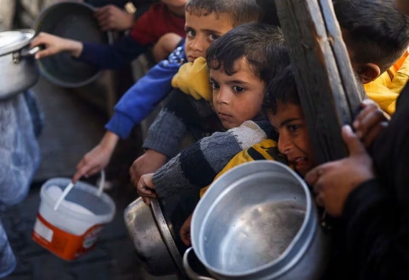 Palestinian children wait to receive food cooked by a charity kitchen amid shortages of food supplies, in Rafah, in the southern Gaza Strip, March 5, 2024. PHOTO: REUTERS