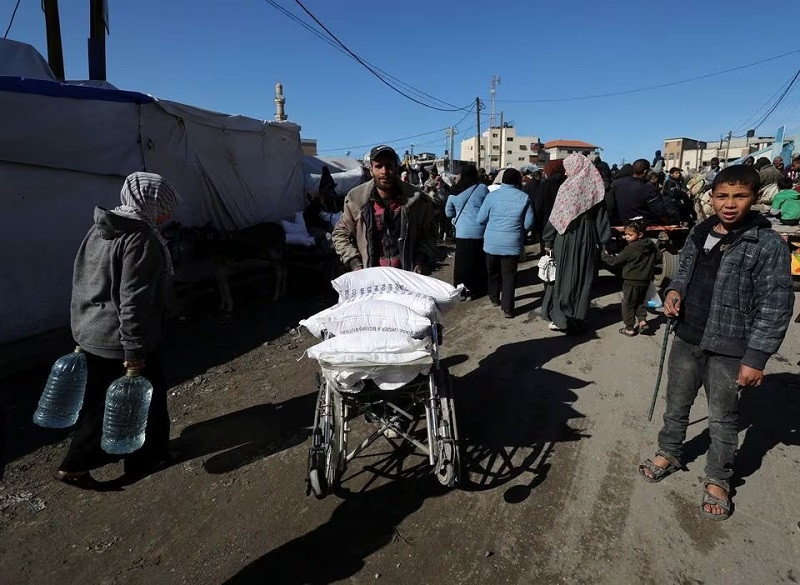 a palestinian man carries bags of flour distributed by the unrwa in rafah in the southern gaza strip february 1 2024 photo reuters