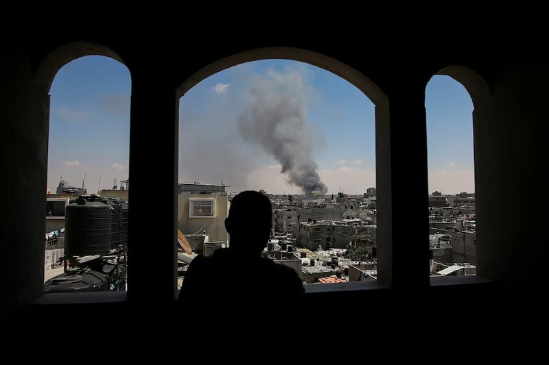 a palestinian man watches as smoke rises after israeli strikes while israeli forces launch a ground and air operation in the eastern part of rafah in rafah in the southern gaza strip may 7 2024 photo reuters